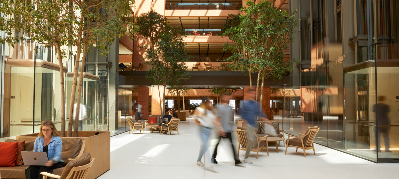 Nedervåningen i Batterseas ljusa atrium med flera Apple-medarbetare som träffas, går och jobbar.