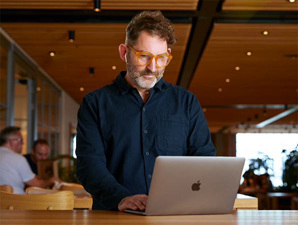 En Apple-medarbetare använder en MacBook på Caffè Macs.
