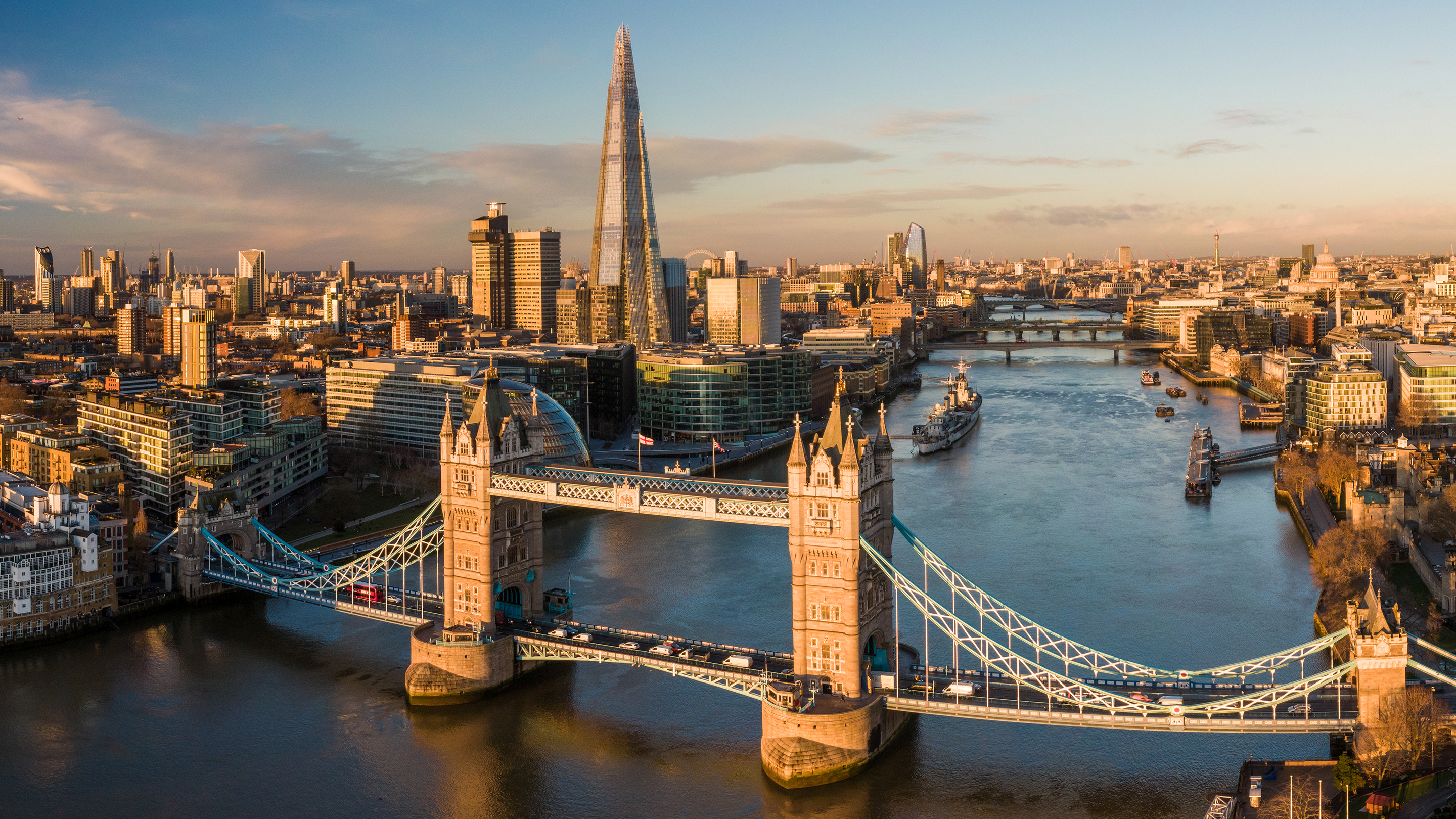 Flygbild över London och floden Themsen med Tower Bridge i förgrunden.