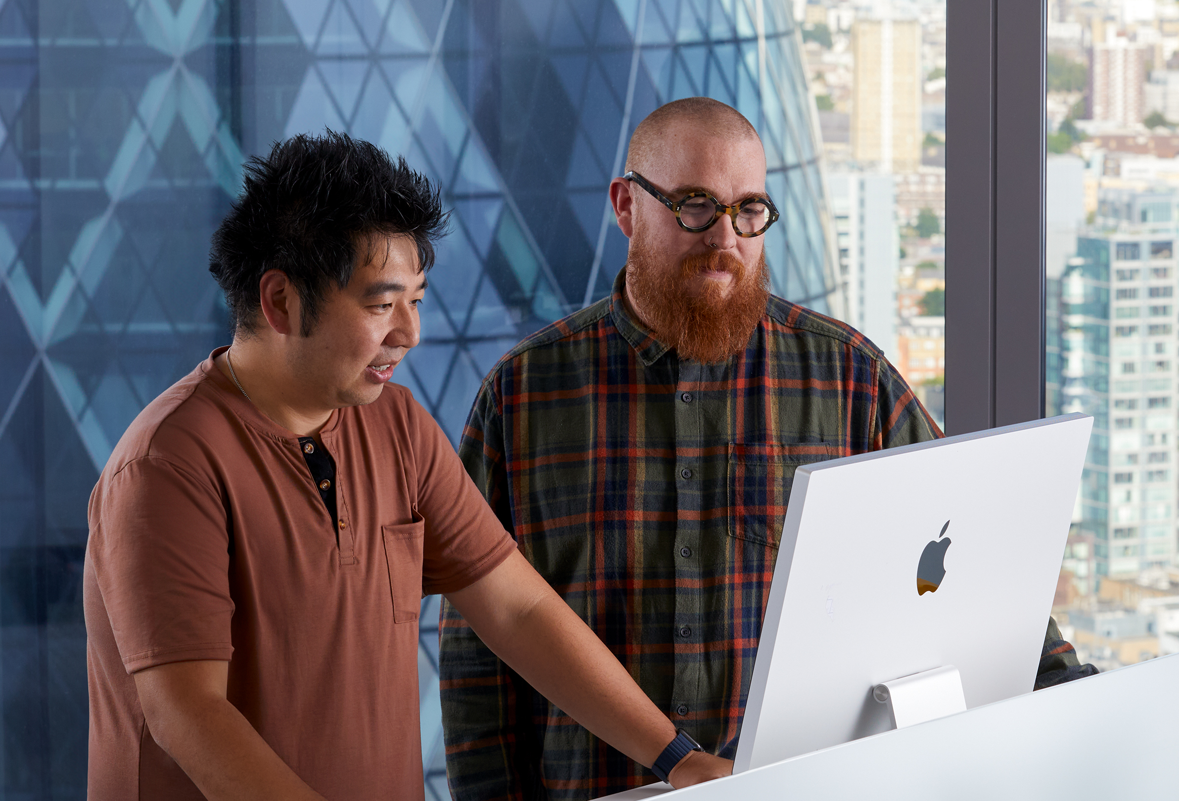 Två Apple-kollegor samarbetar på en iMac.