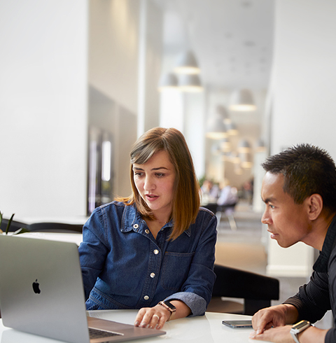 Une employée de l’équipe Assistance et service d’Apple Cork discute avec un collègue.