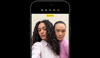 iPhone 18 Pro berwarna Hitam, menghadap depan, menampilkan dua orang dengan fitur pelacakan wajah, menunjukkan fitur kamera depan Center stage