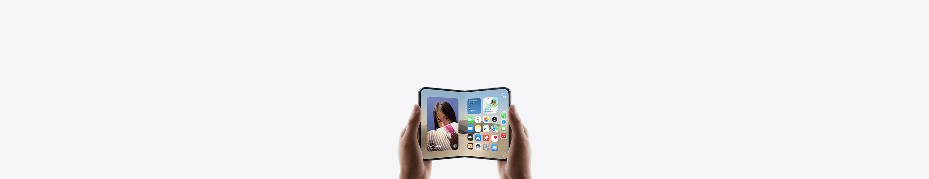 兩隻手拿著橫向放置的 iPhone Duo，裝置展開，內螢幕展示主畫面