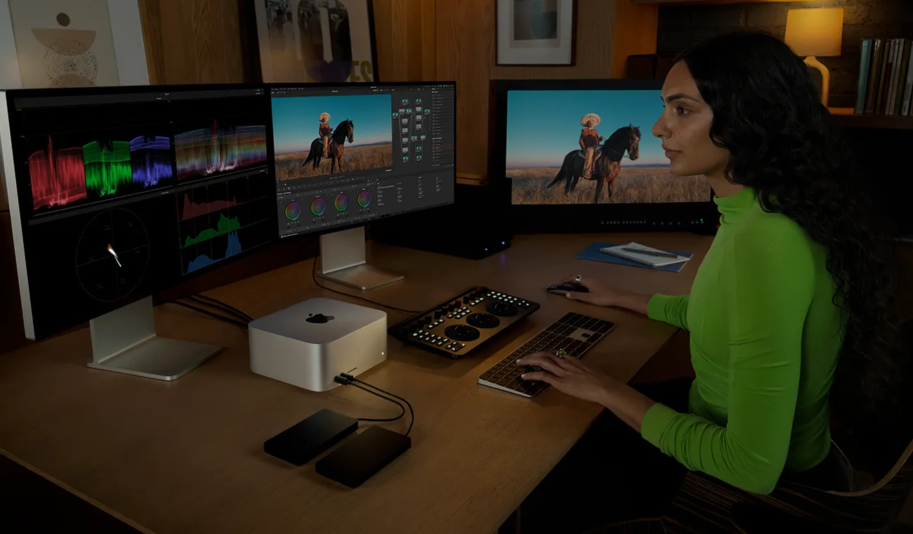 專業人士使用 Mac Studio，以及三部顯示器編輯檔案