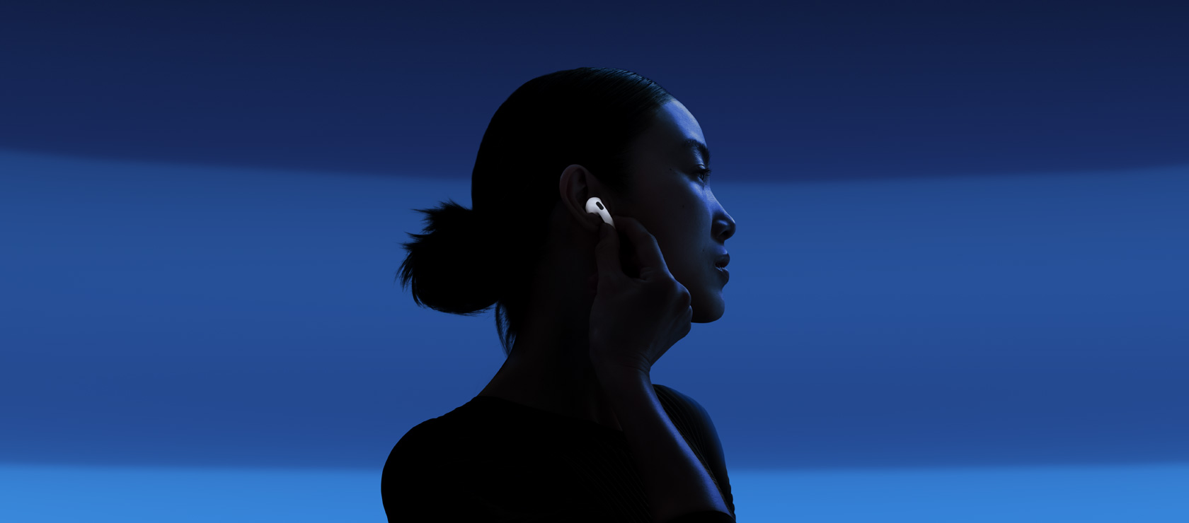Henkilö laittaa päälle aktiivisen melunvaimennuksen koskettamalla AirPods 5 ‑kuulokkeen vartta