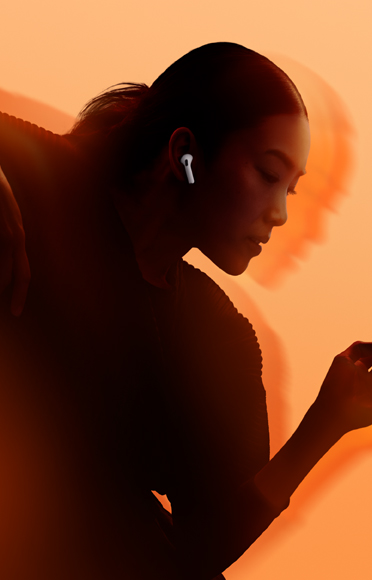 AirPods 5 ‑kuulokkeita käyttävä henkilö, kädet taivutettuina, monivärinen tausta