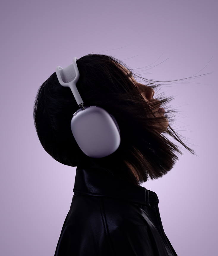 Žmogaus profilis su violetinės spalvos ausinėmis „AirPods Max 2“, galva šiek tiek pakelta