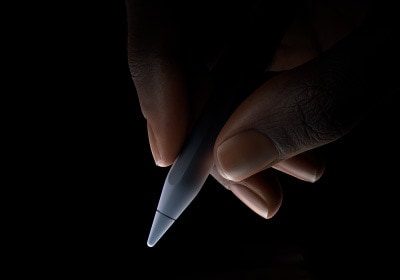 用户以拇指及食指握著 Apple Pencil Pro 筆身底端三分之一的位置，準備書寫。