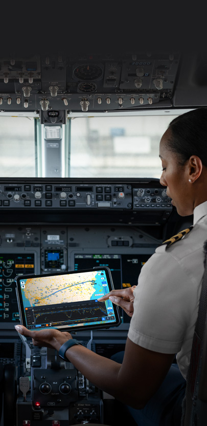 En una cabina, una piloto mira un mapa en la pantalla de un iPad.